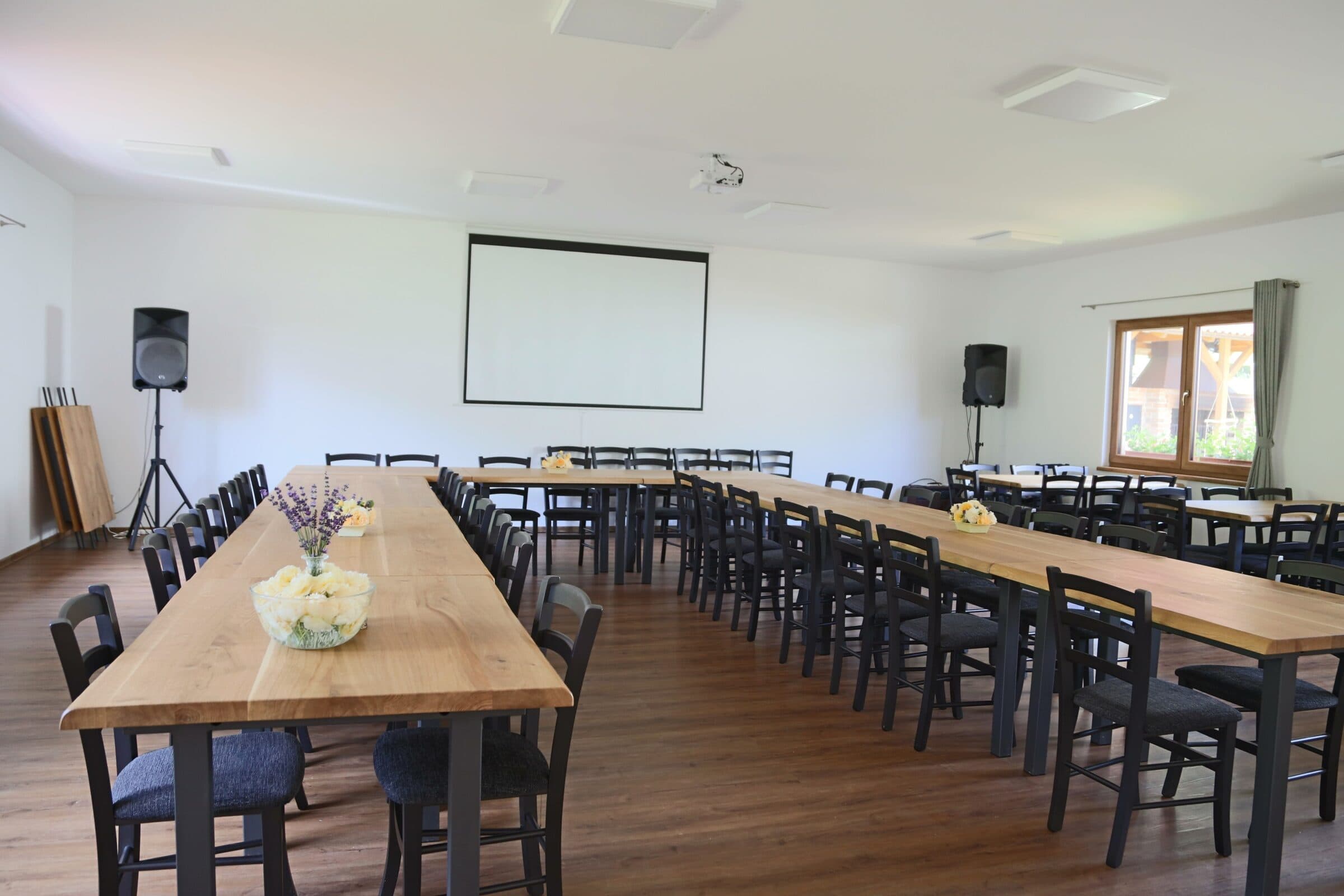Seminarsaal des Letovisko Chobot mit Leinwand und Tischen