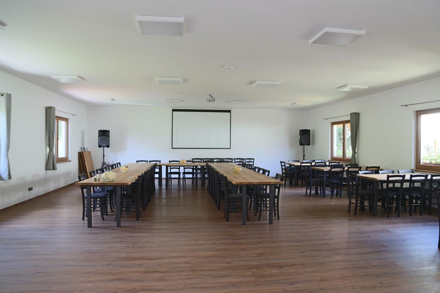 Seminarsaal des Letovisko Chobot mit Holztischen und Leinwand